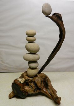 a sculpture made out of rocks on top of a piece of wood