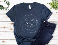 a t - shirt with the moon and stars on it, next to some jeans