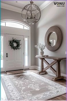 a foyer with a rug, mirror and wreath on the door way to another room