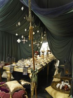 a long table is decorated with stars and other decorations for a holiday dinner or party