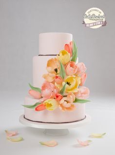 a three tiered cake with flowers on top