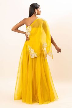 Yellow one shoulder cape with floral pattern, contrast zardozi, crystals and French knot thread placement hand embroidery. Paired with flared lehenga and inner tube top. - Aza Fashions Traditional One-shoulder Festive Sets, Festive Traditional One-shoulder Set, Traditional One-shoulder Set With Dupatta, Yellow Traditional Drape Gown, Traditional One-shoulder Fitted Sets, Elegant One-shoulder Sharara For Wedding, Elegant One Shoulder Sharara For Wedding, Elegant One-shoulder Wedding Sharara, Fitted One-shoulder Traditional Set