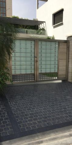 an empty driveway in front of a building with two garage doors and a palm tree