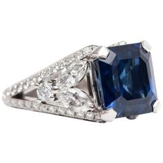 a blue and white diamond ring with two sides cut in to the center, surrounded by diamonds