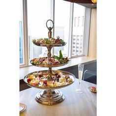 three tiered trays filled with food on top of a table