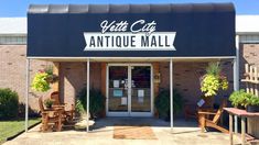 the entrance to an antique mall with chairs and tables