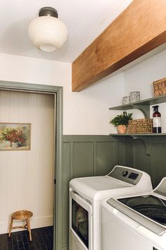 a washer and dryer sitting in a room next to a doorway with shelves on the wall