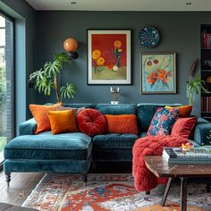 a living room with blue couches and orange pillows on top of the rugs