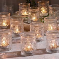 there are many glass candles on the table