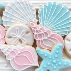 decorated cookies in pastel blue, pink and white with seashells on them