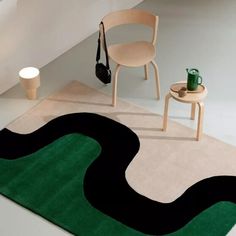 a room with a rug, chair and table on the floor in front of it