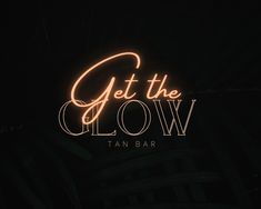 a neon sign that says get the glow tan bar in front of a dark background