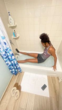 a woman is sitting in the bathtub with her feet on the edge of the tub