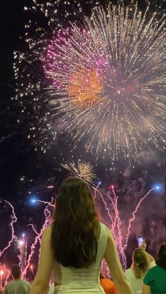 a woman looking at fireworks in the sky