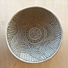 a white bowl sitting on top of a wooden table