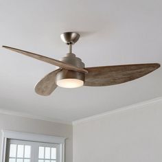 a ceiling fan that is mounted to the ceiling in a room with white walls and windows