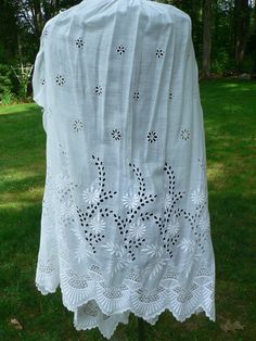 a white shawl draped over a green lawn