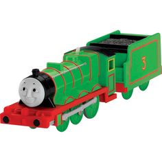 a green and red toy train with a black face on it's engine is shown