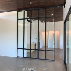 an empty room with glass doors and wood ceiling