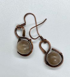 Hand formed Hammered Copper Earrings with Gray Sunstones.Approximately 1 1/4" long from the top of the ear wire and 1/2" wideThese earrings have been antiqued, polished and sealed.Sealed with Protectaclear ProtectaClear is a clear, protective coating that is tough enough to protect jewelry and is safe for wear against skin. ProtectaClear is practically invisible once applied and will seal and protect jewelry from tarnish, oxidation, and corrosion Hammered Copper Earrings, The Ear, Hammered Copper, Copper Earrings, Ear Wire, Copper, Personalized Items, Skin