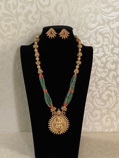 Enhance your style with our stunning Green onyx beads Lakshmi Haaram, paired perfectly with matching earrings. Crafted with high-quality stones & beads, this set combines timeless elegance with a modern touch. Ideal for special occasions or adding a touch of glamour to your Look Kundan Gemstone Necklace For Puja In Temple Jewelry Style, Festive Temple Necklace With Gemstones, Spiritual Temple Necklace With Gemstones For Festive Occasions, Temple Jewelry Beaded Gemstone Necklace For Festivals, Temple Jewelry Beaded Gemstone Necklaces For Festivals, Fusion Style Gemstone Temple Necklace For Diwali, Fusion Gemstone Temple Necklace For Diwali, Festive Gemstone Temple Necklace, Temple Jewelry Bridal Necklace With Gemstones