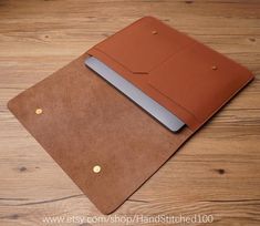 an open brown leather notebook on top of a wooden table