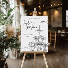 a welcome sign is on an easel in a room with flowers and greenery