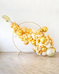 a balloon arch with gold and white balloons