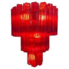 a red light hanging from the side of a wall mounted fixture on a white background