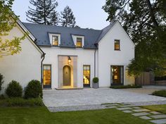 a large white house with two windows and a door in the front yard at night