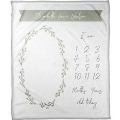 a white blanket with an oval design on it and the date printed in green ink