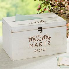 a personalized wooden box sitting on top of a table next to a vase filled with flowers