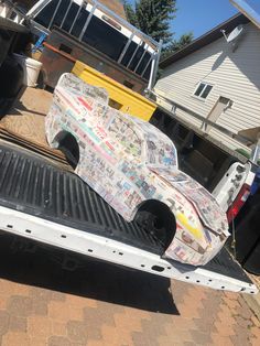 the back end of a truck with newspaper covering it's bed and flatbed