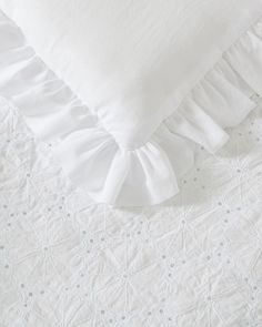 white bedding with ruffled edges and pillows