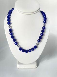 This gorgeous necklace of round lapis lazuli beads with sapphire and white gold accents is the epitome of style and sophistication! 10mm round, beautifully matched lapis with their high-polish and stunning royal blue color have been arranged with 18k white gold rondels, faceted blue sapphire beads and white gold rondels. The larger white gold rondels are set with tiny sparkling sapphires that complement the lapis perfectly, and the white gold accents have a lovely stardust finish, treating your eyes to a wonderful combination of sizes, shapes, color and textures. Hand strung on silk thread and finished with a 14k white gold clasp, this necklace is a great way to show off your sense of style and that undefinable look of understated, effortless elegance! Necklace measures 19 inches in length Sapphire Beads, White Gold Necklace, Lapis Lazuli Beads, White Gold Necklaces, Royal Blue Color, Effortless Elegance, Silk Thread, Gorgeous Necklaces, Gold Accents