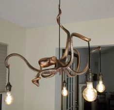 an octopus chandelier hanging from the ceiling with light bulbs in front of it