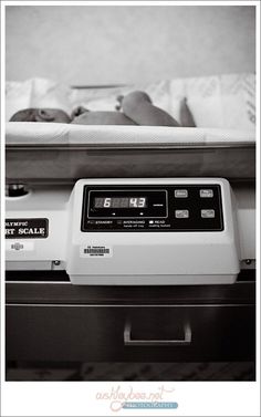 an alarm clock sitting on top of a bed next to a baby in a crib