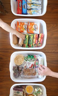 three white containers filled with food on top of a wooden table