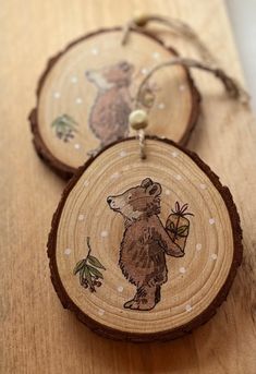 three wooden ornaments with bears on them are hanging from the wood planks that have been decorated