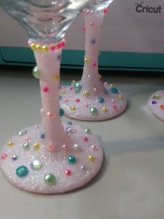 two pink wine glasses with colorful beads on them