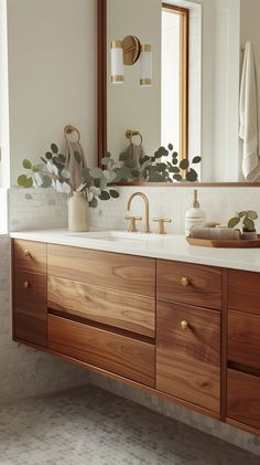 a bathroom vanity with wooden cabinets and mirrors