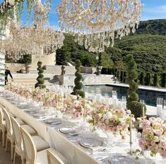 a long table is set with white and pink flowers