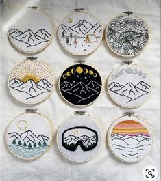 nine embroidery designs are displayed on a white sheet with the sun and mountains behind them