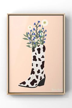 a cow print boot with flowers in it is mounted on the side of a wall