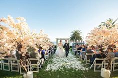 a bride and groom are walking down the aisle