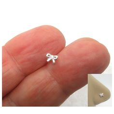 a tiny bowknot ring is shown on someone's finger, with the image in