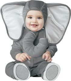 a baby in an elephant costume sitting on the ground