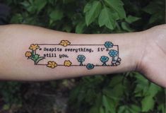 a person with a tattoo on their arm that says, despite everything is still you