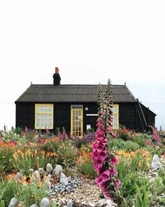 the house is surrounded by flowers and rocks