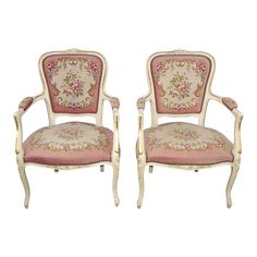 a pair of chairs with pink and white floral upholstered backrests on each side